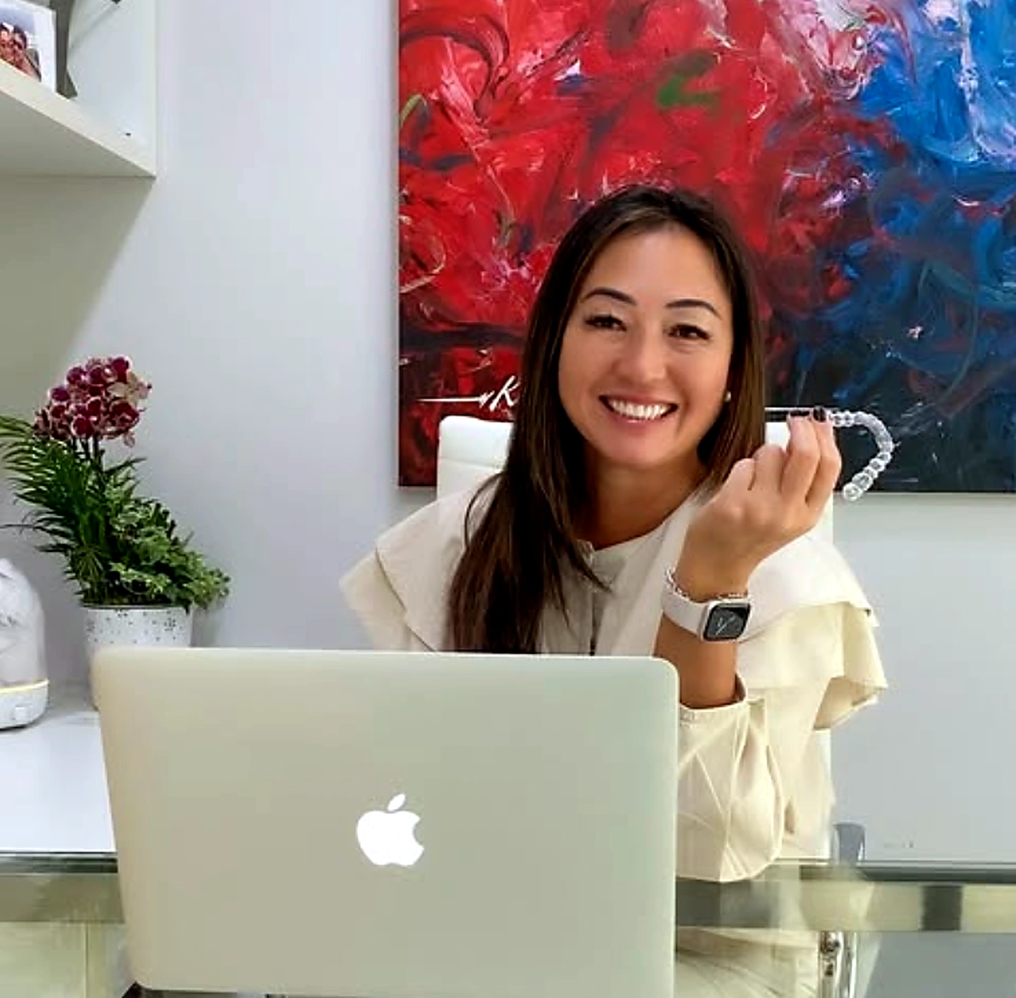 Dra. Yoko Ogura segurando um alinhador transparente em seu consultório
